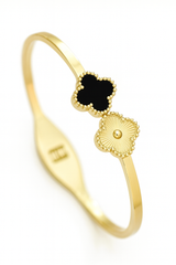 Gold ring with black clover and engraved letter 'E' on a white background