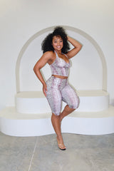 Woman in a matching top and shorts set posing on a white platform.