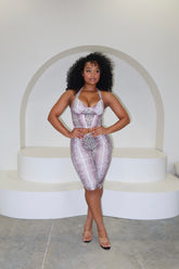 Woman in a sequin dress standing in front of a white archway.