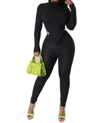 Woman wearing a sleek black full-length jumpsuit with long sleeves, side cutouts, and a sculpted corset-style bodice.