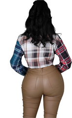Woman wearing a multicolor plaid cropped button-up shirt with long sleeves and chest pocket detail.