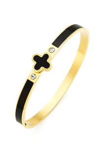 Gold bracelet with black clover design on a white background