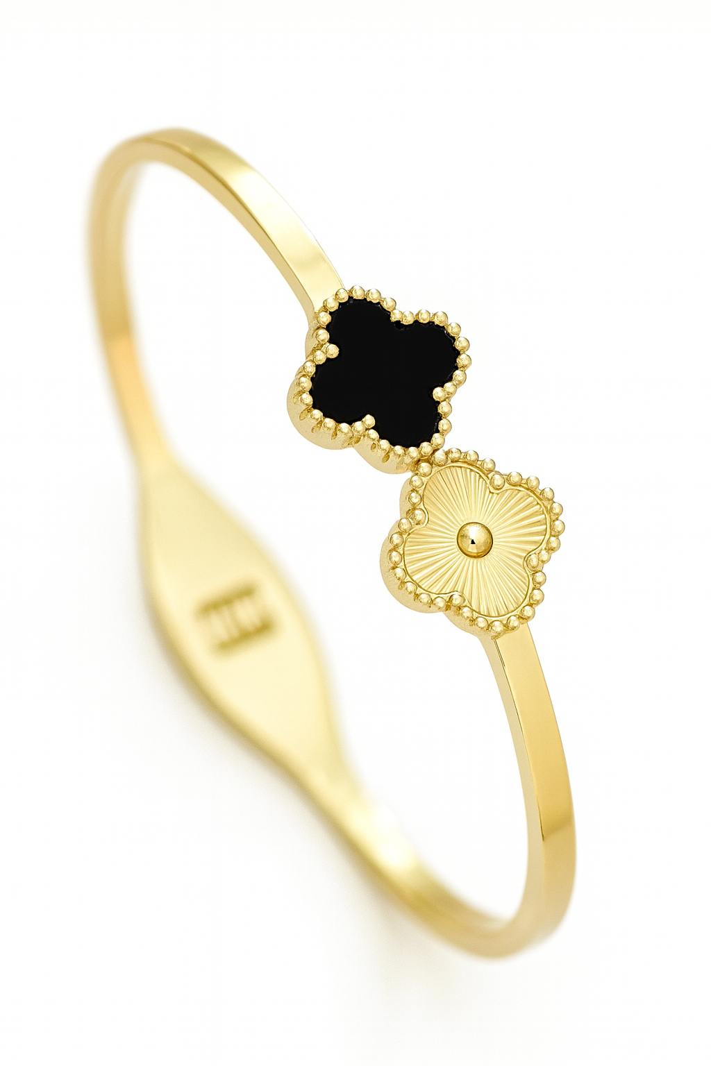 Gold ring with black clover and engraved letter 'E' on a white background
