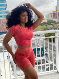 Woman wearing a red acid wash two-piece set featuring a fitted crop top and high-waisted biker shorts.