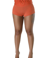 Back view of matching rust orange ribbed knit fitted shorts underneath the skater dress.