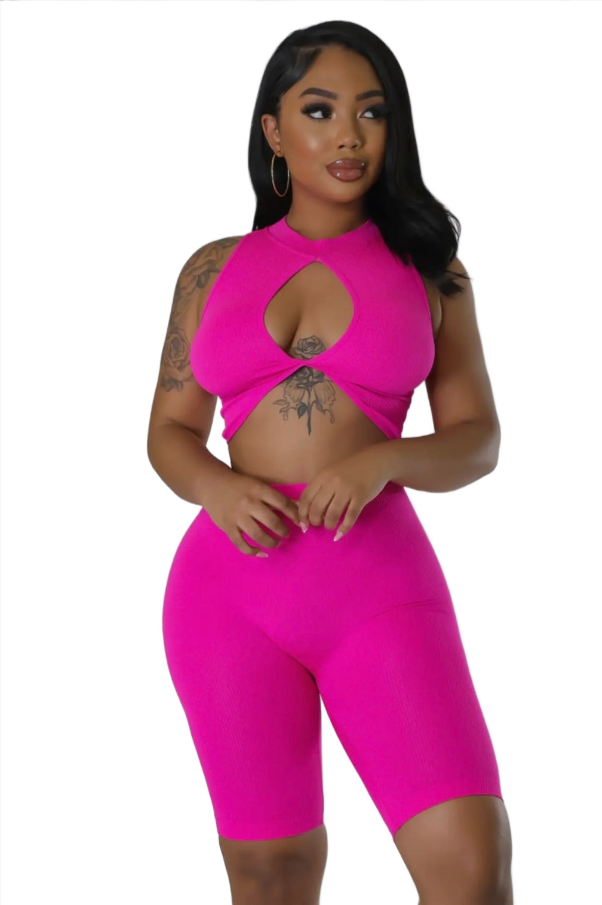 Woman in a hot pink two-piece set featuring a sleeveless crop top with a keyhole cutout and matching fitted shorts.
