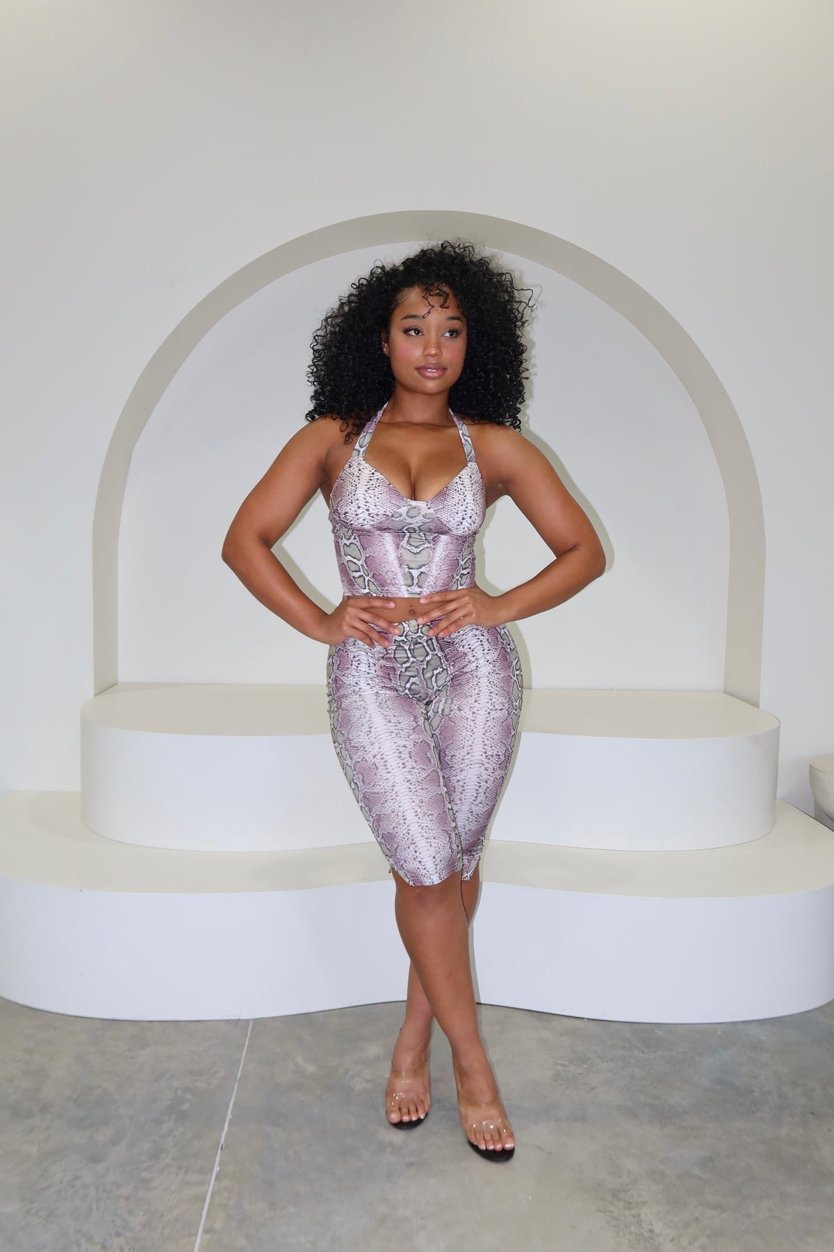 Woman in a sequin dress standing in front of a white archway.
